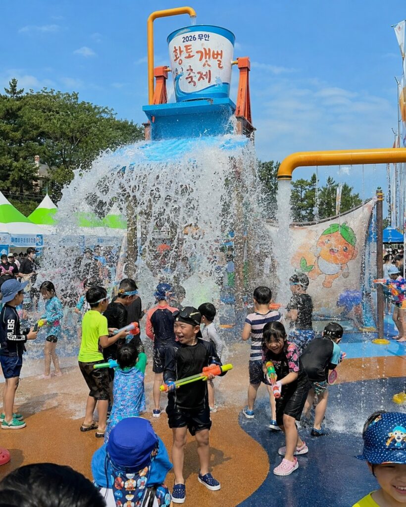 Children playing in the water zone at the Muan Mudflat Festival